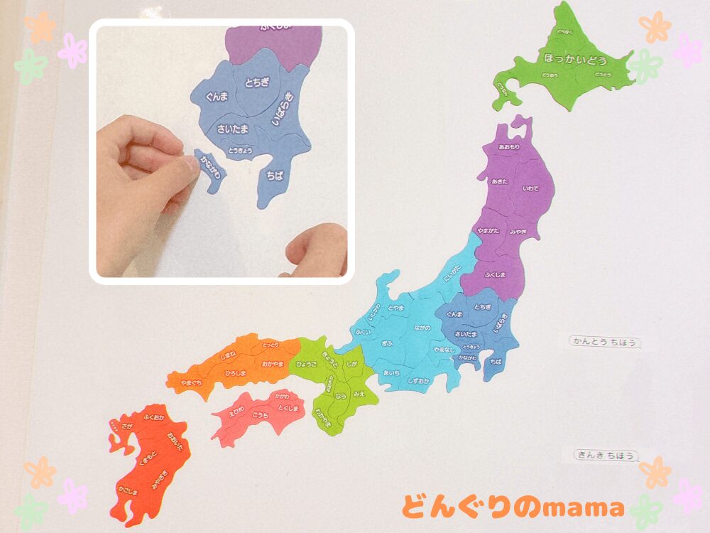 ホワイトボードに貼ったマグネット式都道府県パズルを組み立てる子どもの手元