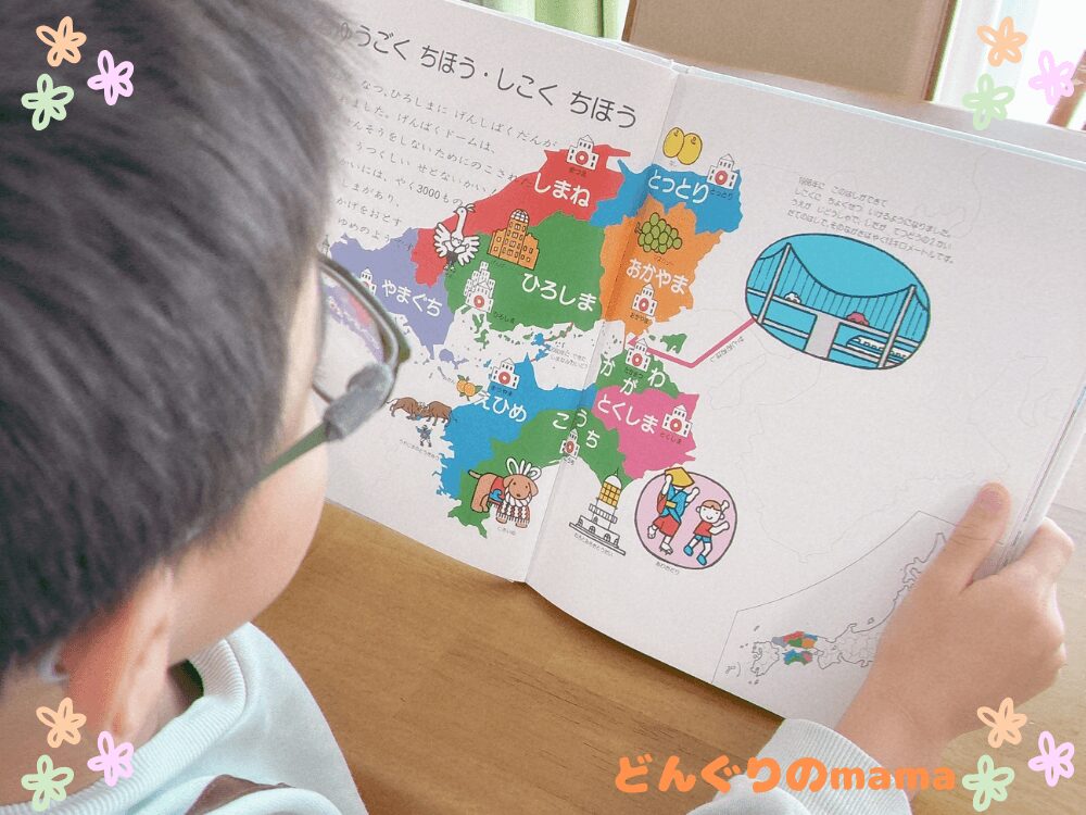 日本地図の絵本を読む小学生の後ろ姿