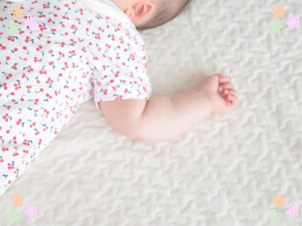 寝転がる赤ちゃんの手元と後頭部の様子